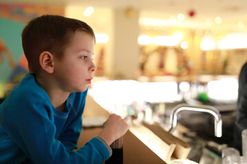 Child waiting food at bar of restaurant