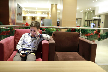 Child with smartphone in hotel lobby