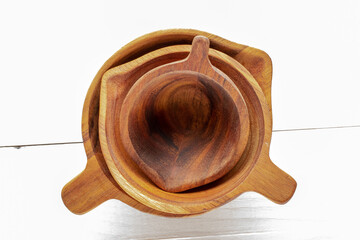 Three natural wood cups on a wooden table, macro, top view.