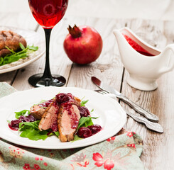 Duck breast with sauce on wooden background.