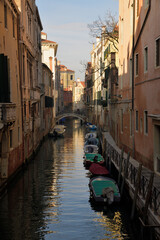 Obraz na płótnie Canvas Einer der vielen kleinen Wasserkanälen in Venedig, bei den kleine Boote an einem Fußweg liegen. 
