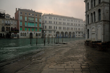 Das Hochwasser des Canale Grande in Venedig schwappt am frühen Morgen über die Uferpromenade und...