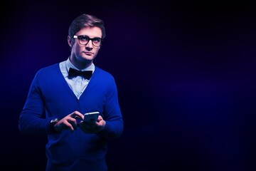 Portrait of excited handsome young man looking at the mobile phone