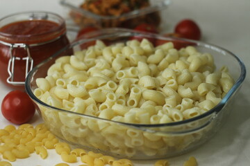 Boiled macaroni pasta inside a square glass bowl