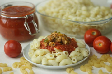 Macaroni pasta served with red sauce and Sauteed chicken and bell peppers on top