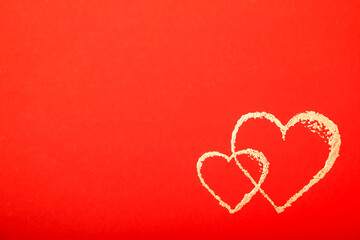 Golden outline of two hearts on red background. Copy space