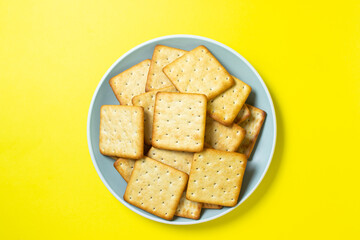 Crackers on a yellow background. Fresh crispy crackers on a plate.