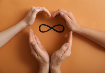 Infinity symbol and human hands making heart on color background. Polyamory concept