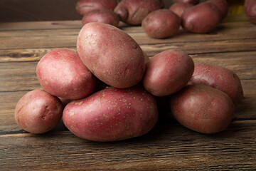 Red potatoes on a wooden background.Fresh vegetables on the table.