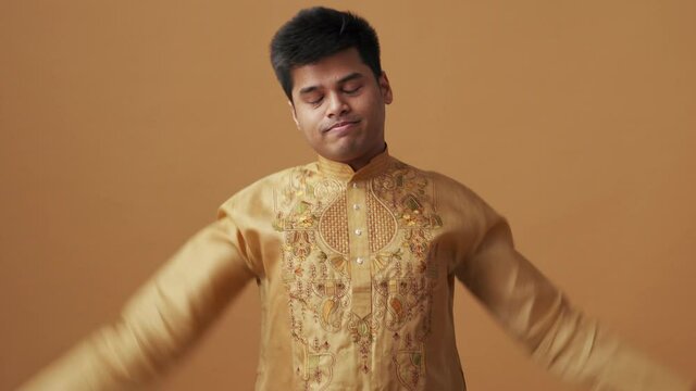 Bored Indian man in national cloth putting his head down in the orange studio