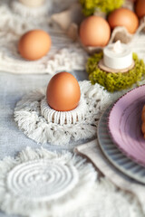 Obraz na płótnie Canvas Cozy elegant festive table decor for Easter in a light tone. handmade macrame products, eggs.