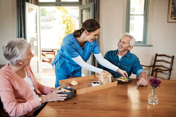 It's even better than a restaurant. Shot of a young nurse checking up on a senior couple during breakfast at a nursing home.