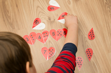 Counting heart shape game. dots and numbers. find a pair. wood background. kid playing on the...