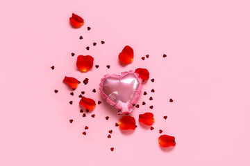 Heart shaped balloon, rose petals and confetti on pink background. St. Valentine's Day