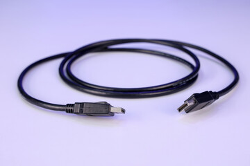 A Computer DisplayPort 1.2 cable rolled on a White table. It is used to connect a Monitor to a PC. It supports 4K resolution up to 3840 x 2160 pixels. It is also called DP Cable, and it's not an HDMI.