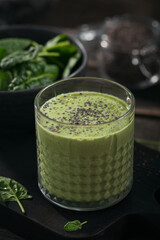 Glass of homemade healthy green smoothie with fresh baby spinach