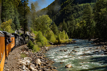 Durango, Colorado - 9-21-2021: A steam engine locomotive with tourist passengers along the animas river on the Durango to Silverton scenic railroad, colorado
