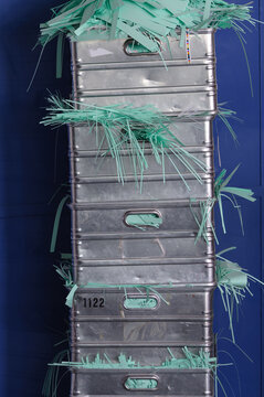 Vier aluminium Kisten gestapelt, mit gr&uuml;nen Papierstreifen, frontal