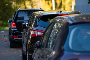 car row in a parking lot near an apartment house on a sunny autumn day, rear view, close-up