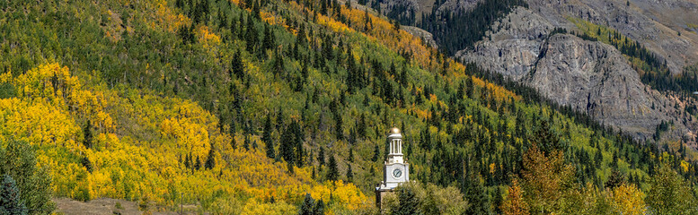 The clock tower of the county courthouse with a bockground of colorful aspen trees in Selverton,...