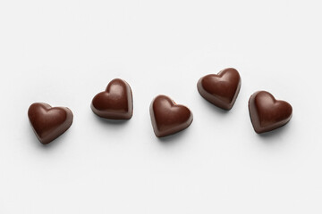 Tasty heart-shaped candies on white background