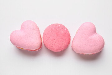 Tasty heart-shaped macaroons on white background