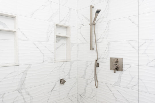 Detail Of Walk In Shower With White And Gray Subway Tile And Chrome Hardware.