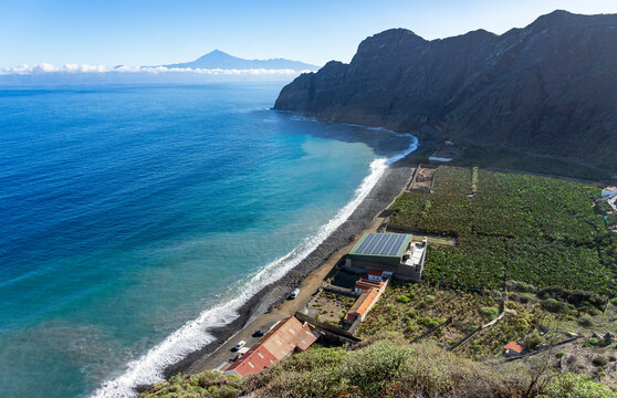 Der grüne hügelige Norden von Gomera, Kanarische Inseln: Panorama Blick die Bucht und den Strand vom Dorf Hermigua mit Blick auf den Teide mit Bananen-Plantagen