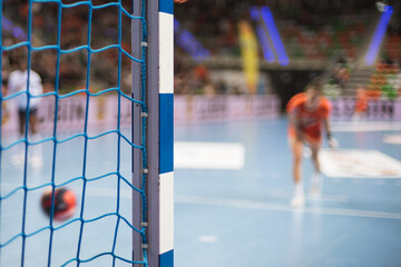 Detail of handball goal post with net and penalty shot in the background.
