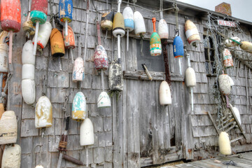 lobster buoys of various color on shack
