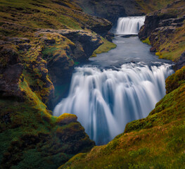 Dramatic summer scenery. Picturesque morning scene of waterfall on Skoga river. Stunning summer view from the tourist trek from famous Skogafoss waterfall to the top of the river, Iceland, Europe.