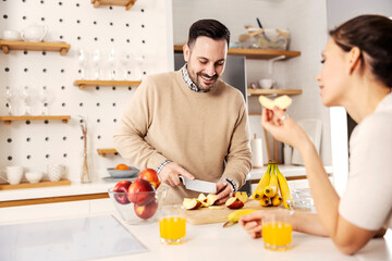 A man in kitchen preparing healthy snack for his wife at their cozy apartment.