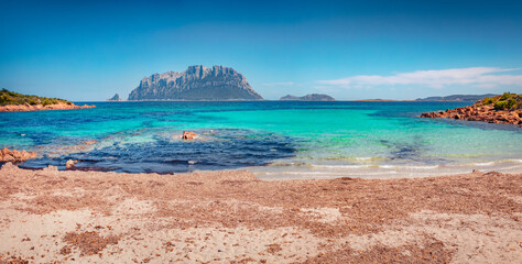Beautiful marine scenery. Sunny spring view of Tavolara island from Spiaggia del dottore beach. Picturesque morning scene of Sardinia island, Italy, Europe. Vacation concept background..