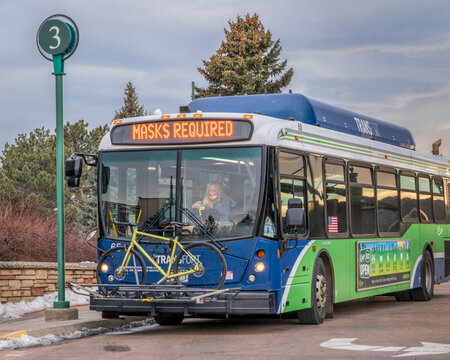 Fort Collins, CO, USA - January 18, 2022: Transfort Bus With A Female Driver, A Bike On Racks And Masks Required Banner At A Stop. Transfort Is A City Public Transportation Service.