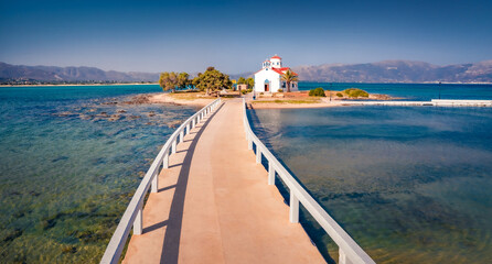 Naklejka premium Exciting summer view of Saint Spiridon church in Elafonisos port. Captivating morning seascape of Mediterranean Sea. Perfect outdoor scene of Elafonisos island, Greece, Europe.