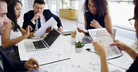 Doing a bit of strategizing. Cropped shot of a group of businesspeople sitting around the boardroom...