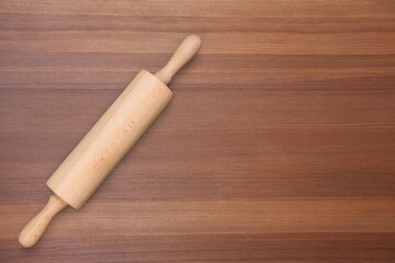 Wooden rolling pin, on rustic wood background. Kitchen utensils on the desk