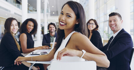 You've gotta earn your seat. Cropped shot of a young businesswoman smiling in an office during a...