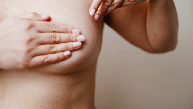 Caucasian woman chest looking for signs of male breast cancer. Breast examination by herself