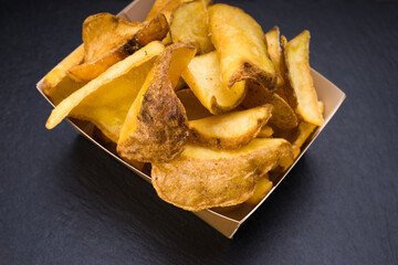 foil with potato chips with peel on dark background