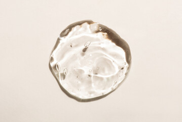 Transparent hyaluronic acid gel on a beige background.