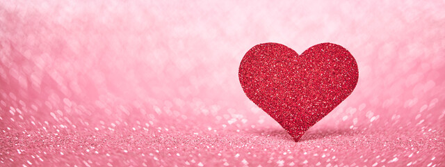 Valentine's Day web banner with red heart, love symbol on pink sparkle background.