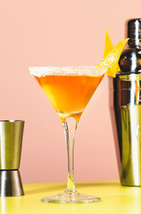 Sidecar alcoholic cocktail with cognac, liqueur, lemon juice and ice. Pink and green background, copy space