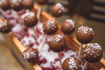 Beautiful multicolored decorated baked sweet tasty candy bar dessert on kids children party with happy people around, catering banquet table