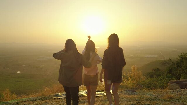 girl friend group Asians blogger standing and caper enjoying the beauty of nature in the evening sunset and shoot video from their action cams to show off to their friends in social media,freedom conc