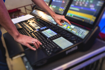 View of lighting technician operator working on mixing console workplace during live event concert on stage show broadcast, light mixer controller panel, sound technician with professional equipment