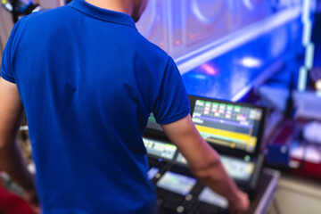 View of lighting technician operator working on mixing console workplace during live event concert...