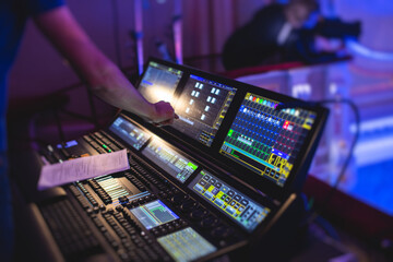 View of lighting technician operator working on mixing console workplace during live event concert on stage show broadcast, light mixer controller panel, sound technician with professional equipment - obrazy, fototapety, plakaty