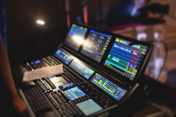 View of lighting technician operator working on mixing console workplace during live event concert on stage show broadcast, light mixer controller panel, sound technician with professional equipment