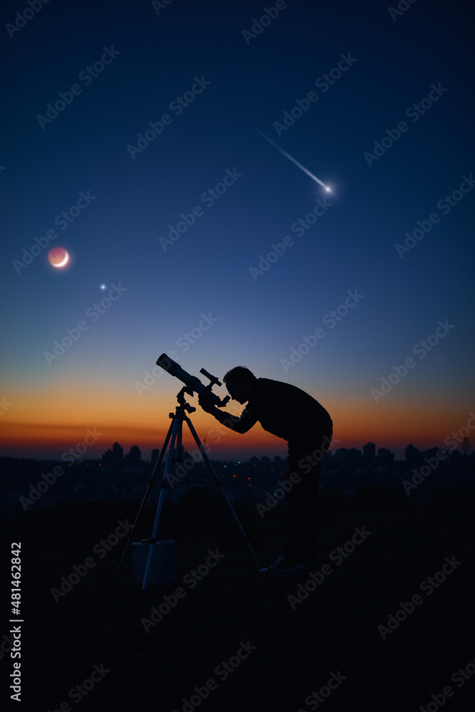 Wall mural silhouette of a man and telescope under the starry skies.